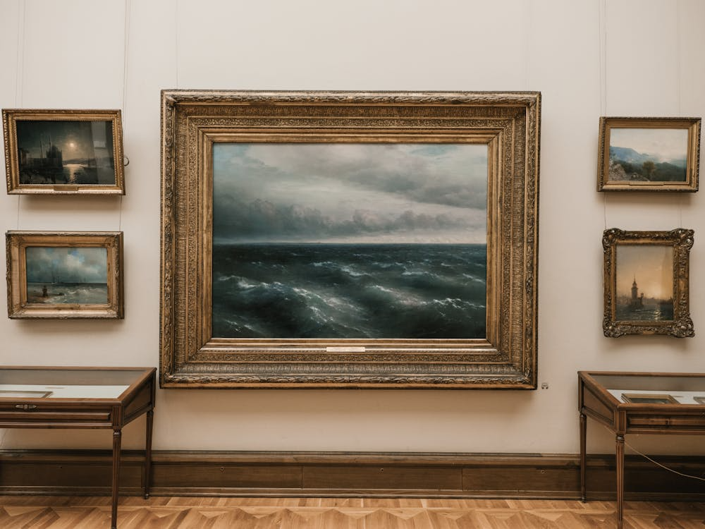 Framed seascape paintings displayed on a museum wall