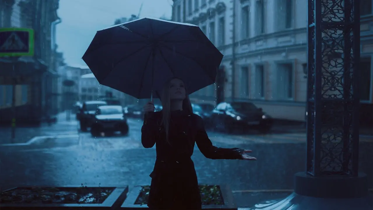 Rainy city scene with a person holding an umbrella
